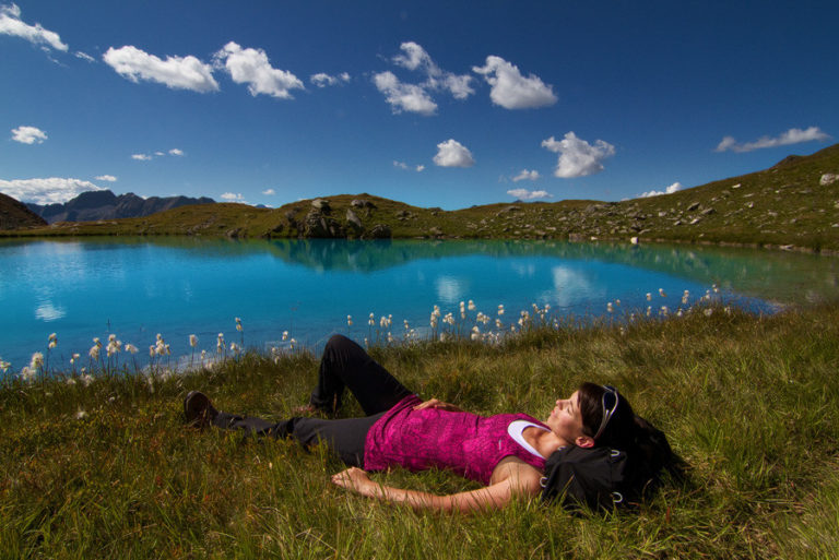 Frau liegt entspannt am Bergsee